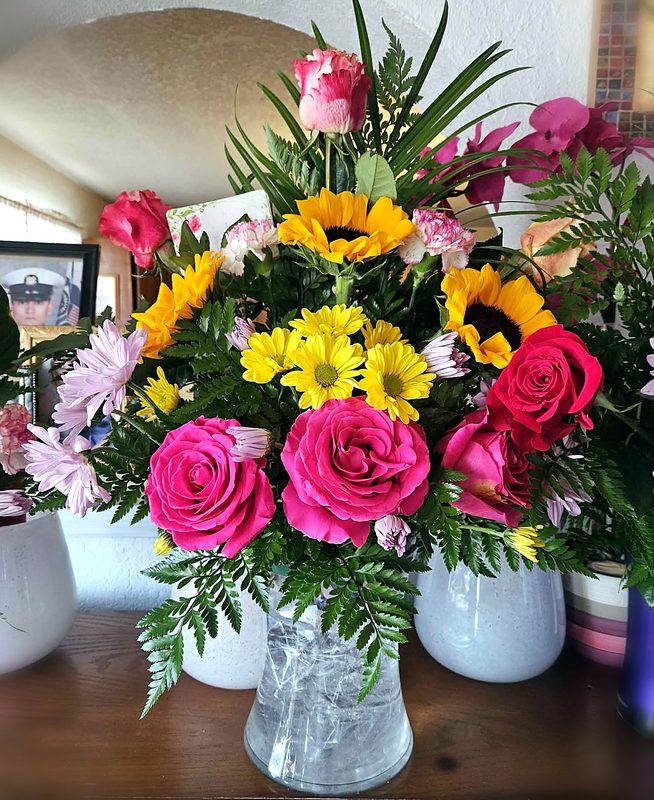 Rosas fiusha y girasoles en florero
